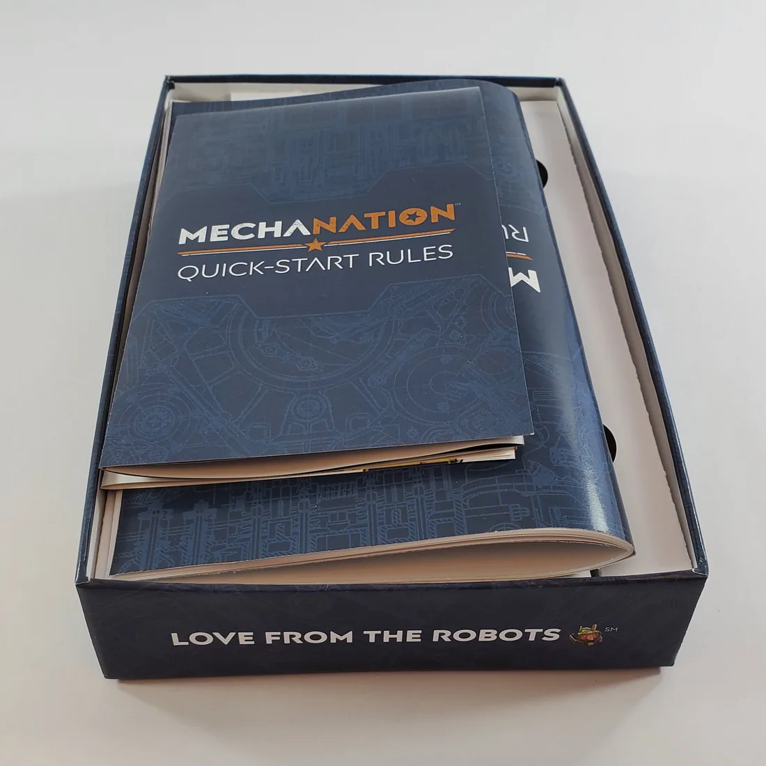 Open Mecha Nation prototype box with printed quick-start rules